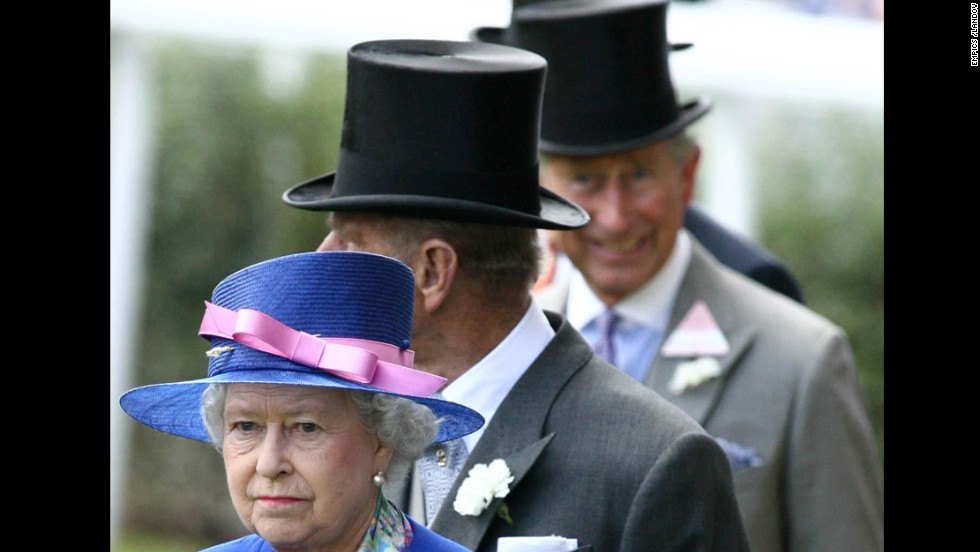 Charles, out of focus, smiles at the camera while following his mother and his father, Prince Phillip, Duke of Edinburgh. for the first day of the royal meeting at the new state-of-the-art course at Ascot in Berkshire in June 2006. 