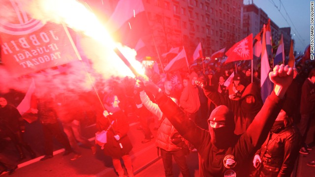 People hold burning flares as they march through the the centre of Warsaw, Poland on Monday,  November 11.