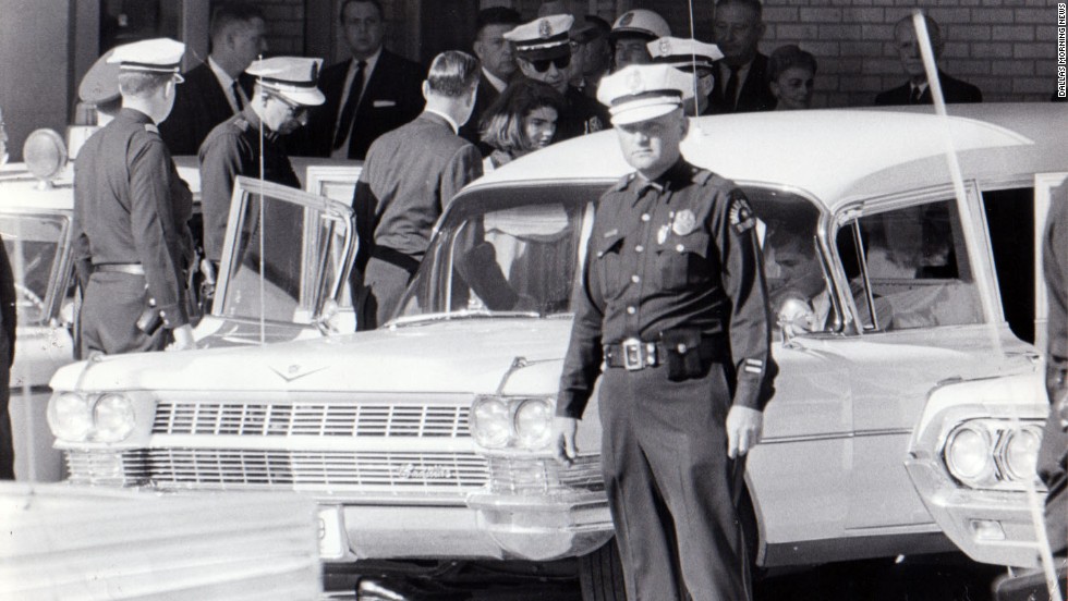 After 2 p.m., Jacqueline Kennedy leaves Parkland Hospital with her slain husband&#39;s body. She would ride in the back with the bronze casket. &quot;I had a feeling that if somebody had literally fired a pistol in front of her face that she would just have blinked,&quot; said Dallas Police Officer James Jennings, who helped put the casket in the hearse. 