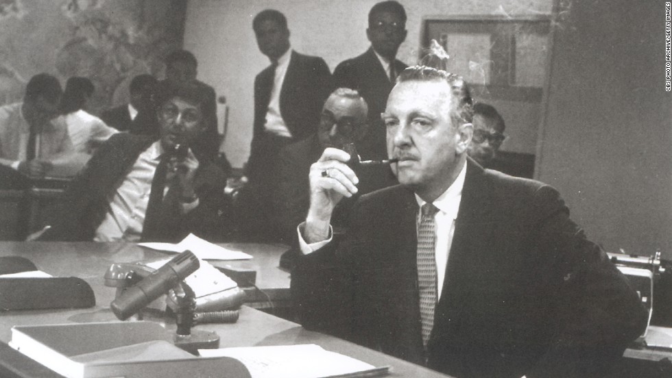 Walter Cronkite sits behind the news desk on the set of the &quot;CBS Evening News with Walter Cronkite&quot; in August 1963. One month later, it became network television&#39;s first nightly half-hour news program.