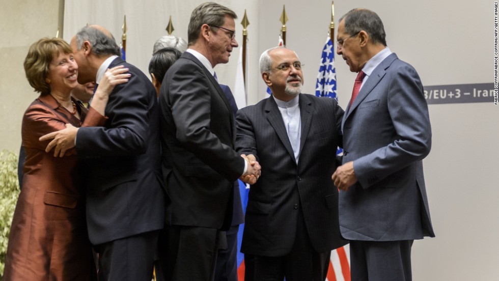 EU foreign policy chief Catherine Ashton and French Foreign Minister Laurent Fabius share a hug while German Foreign Minister Guido Westerwelle, Iranian Foreign Minister Mohammad Javad Zarif and Russian Foreign Minister Sergei Lavrov talk. 