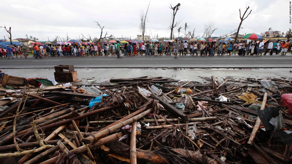 Typhoon survivors walk down a road in Palo, Philppines, during a procession for typhoon victims on November 24.