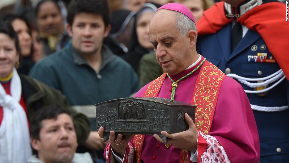 Italian archbishop Rino Fisichella holds the ashes of St Peter before a ceremony of Solemnity of Our Lord Jesus Christ the King at St Peter&#39;s square on November 24, 2013 at the Vatican.