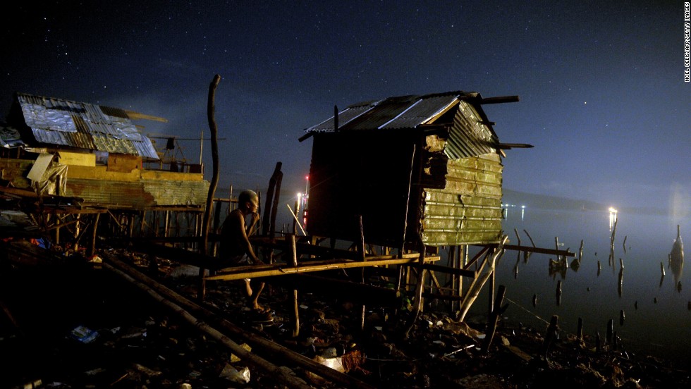 A man rests on his damaged house along the shore in Tacloban on Monday, November 25.