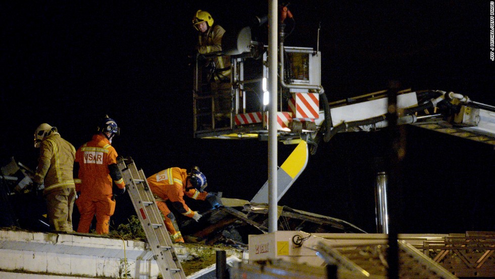 Emergency responders work on the wreckage on top of the pub. 