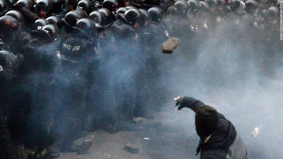 A Ukrainian protester throws stones at riot police during clashes outside the president&#39;s office on December 1.