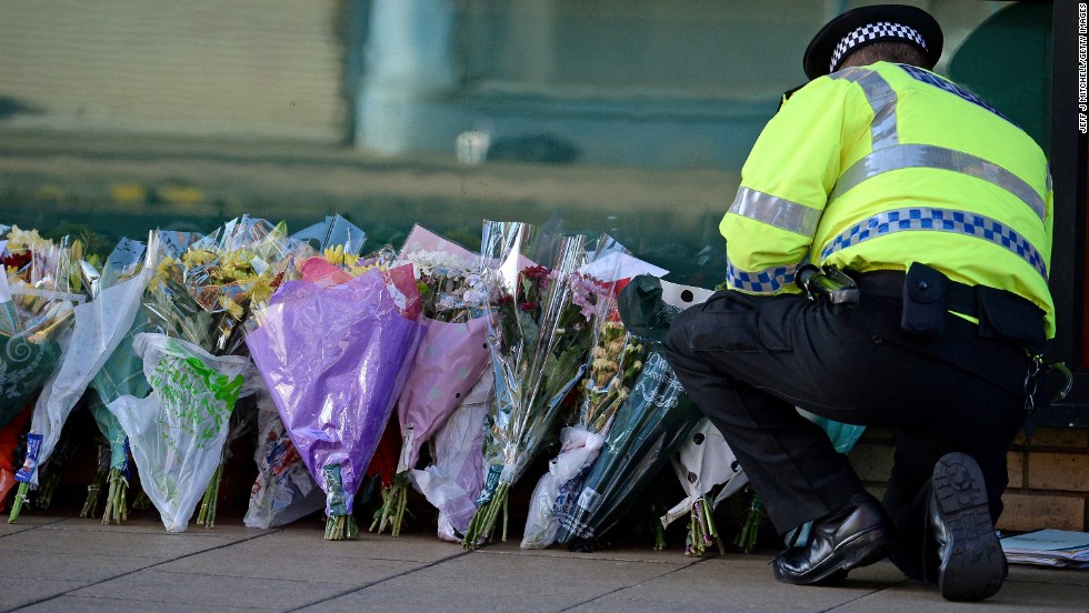 A police officer lays flowers new the pub on Sunday, December 1.