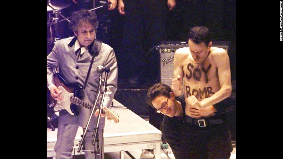 Performance artist Michael Portnoy is taken off stage during Dylan&#39;s performance at the Grammy Awards in 1998. Portnoy had been hired as part of the background dancers for the performance, but his shirtless interruption was not planned and he was carted off stage.