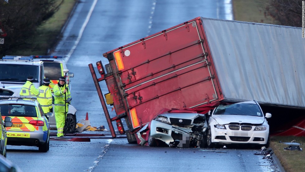 Police work at the scene where a semi-truck was blown onto other vehicles in West Lothian, Scotland, on December 5. The truck driver was killed in the accident.