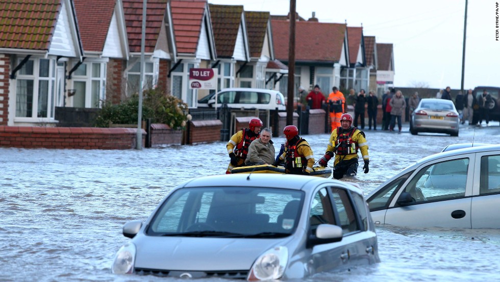A rescue team helps a man across floodwaters in Rhyl on December 5.