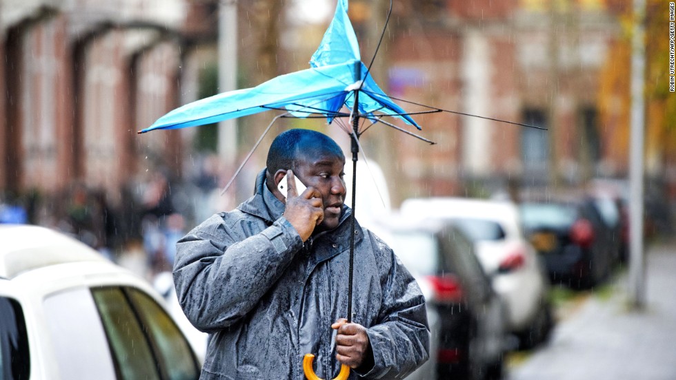 A man walks with a broken umbrella December 5 in Utrecht, Netherlands.