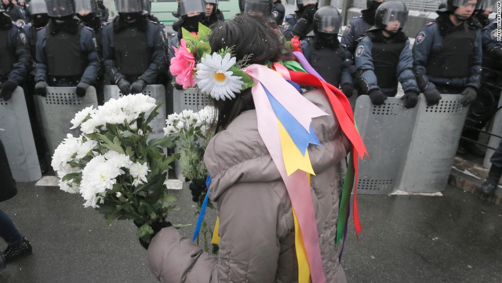 A pro-EU activist offers flowers to police officers at the presidential office in Kiev on December 8.