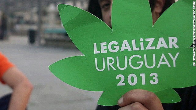 Youngsters wait outside the Parliament building (background) while lawmakers debate the bill legalizing marijuana, in Montevideo, on July 31, 2013. 