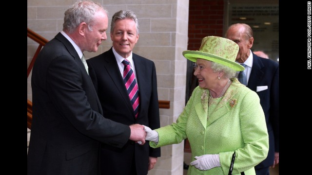 Queen Elizabeth II shakes hands with Northern Ireland's Deputy Prime Minister Martin McGuinness as Prime Minister Peter Robinson looks on at the Lyric Theater in Belfast, Northern Ireland on June 27, 2012.  