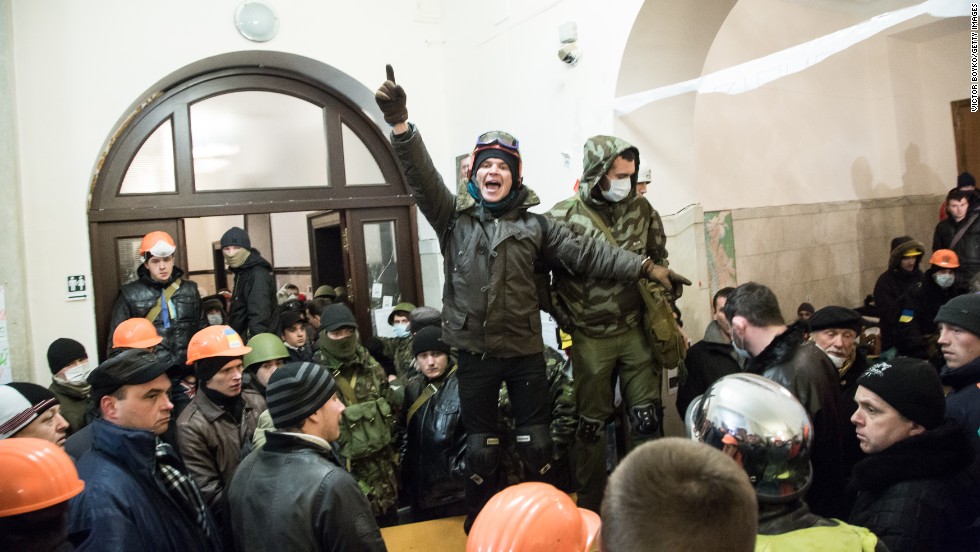 A protester calls for attention inside Kiev&#39;s City Hall after riot police were forced out from blocking the front door on December 11.