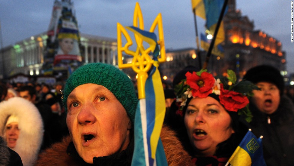 People sing, shout slogans and wave Ukrainian and EU flags during a mass rally in Independence Square on December 15.