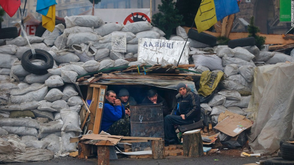Activists warm themselves beside a bonfire as they guard barricades at Independence Square on Monday, December 16.