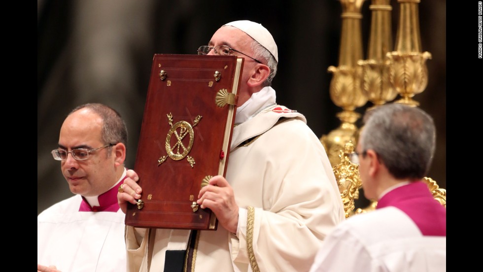 The Pope kisses the book of the Gospels. &quot;God is light and in him there is no darkness at all,&quot; the Pope said.
