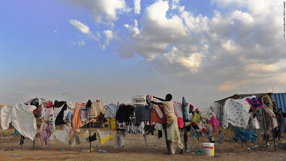 A South Sudanese girl puts her family&#39;s laundry out to dry on a barbed-wire fence at a makeshift U.N. camp in Juba on December 22.