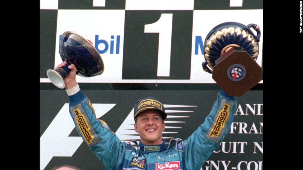 Schumacher holds up the victory trophy, left, and the French Republic President&#39;s trophy after winning the French Formula 1 Grand Prix in Magny Cours, France, in 1995.