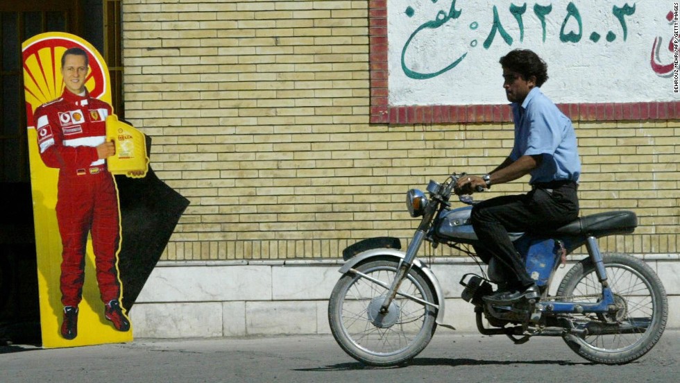 A man rides past a poster with Schumacher&#39;s likeness in Bahreman, Iran, in 2005.