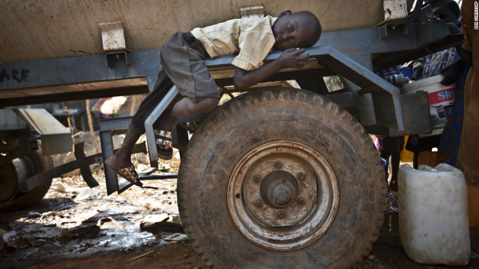 A boy rests on the fender of a water truck Tuesday, December 31, at a United Nations compound on the outskirts of Juba, South Sudan. The compound has become home to thousands fleeing the recent fighting in South Sudan. 