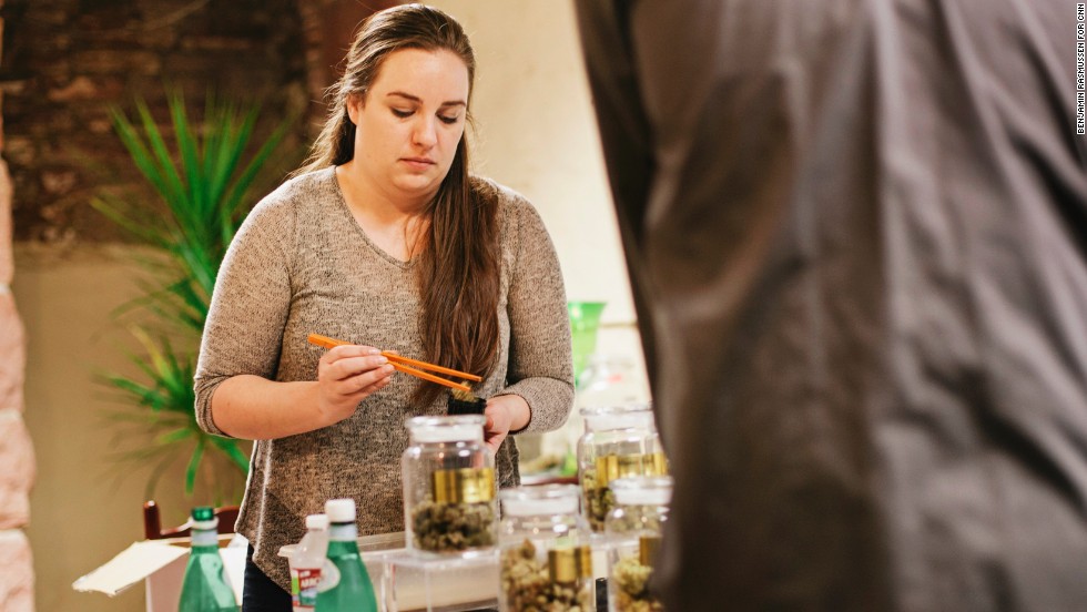 Hailey Andrews, who manages the LoDo Wellness Center, fills an order for a customer. Colorado residents can now buy marijuana like alcohol, but purchases are limited to an ounce at a time.