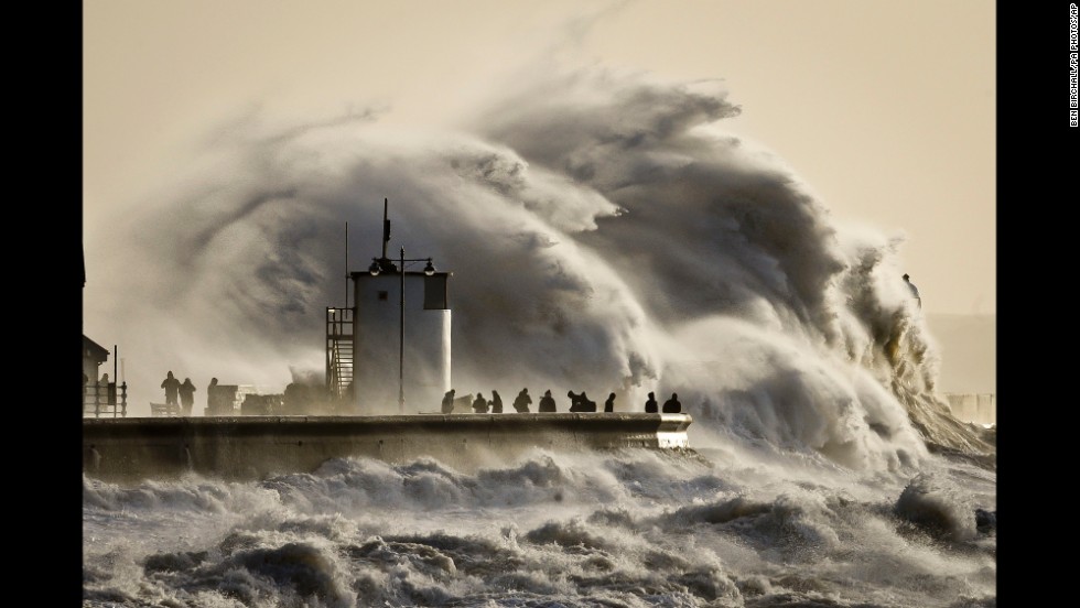 People watch enormous waves break in Porthcawl harbor in South Wales, United Kingdom, on January 6.