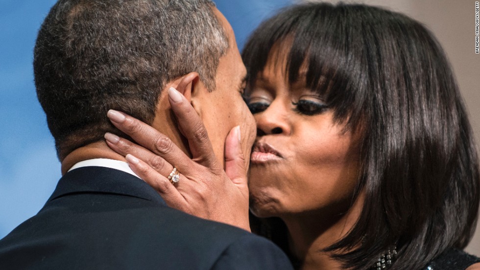 Obama kisses her husband during an inauguration reception at the National Building Museum in Washington in January 2013.