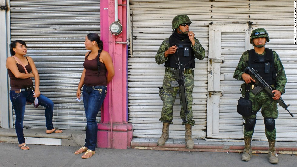 Mexican soldiers patrol the streets of Apatzingan on January 16. The situation with the vigilantes has become a major problem for President Enrique Peña Nieto&#39;s government, which has vowed to reduce drug violence.