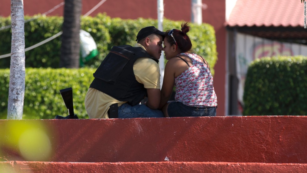 A man belonging to a group called the Self-Defense Council of Michoacan kisses a woman in Nueva Italia&#39;s main square on Monday, January 13.