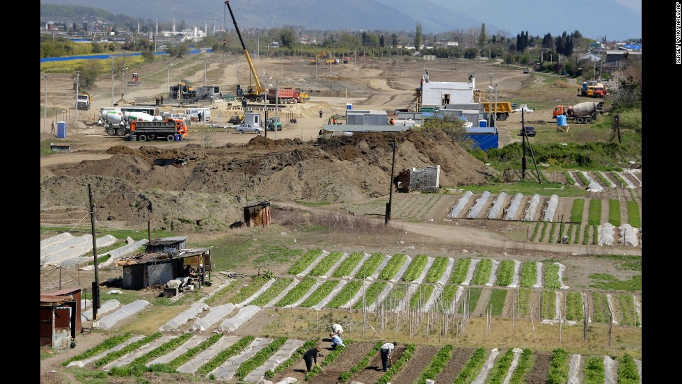 People work on their vegetable gardens near the construction site of the Olympic facilities in the Imeretinskaya Valley in April 2009.