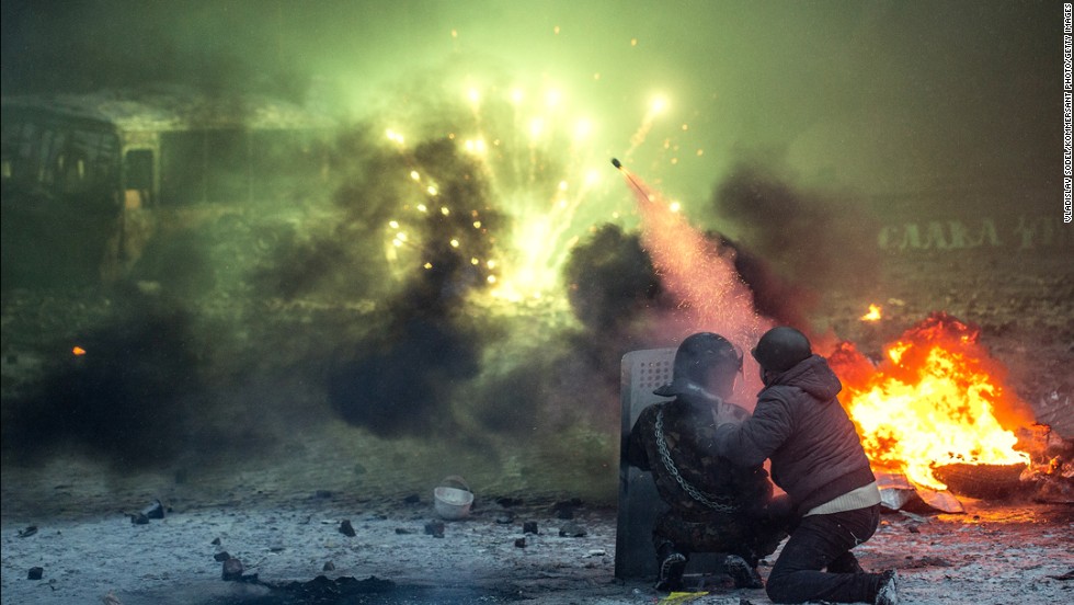 Protesters shoot from behind a shield among burning automobile tires in Kiev on January 22.