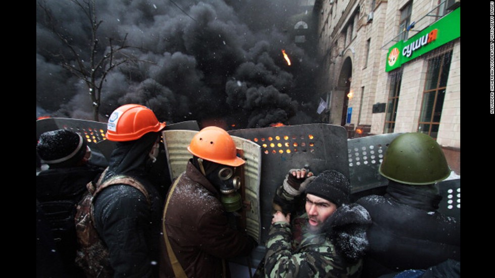 Protesters are seen in front of burning tires on Grushevsky Street.