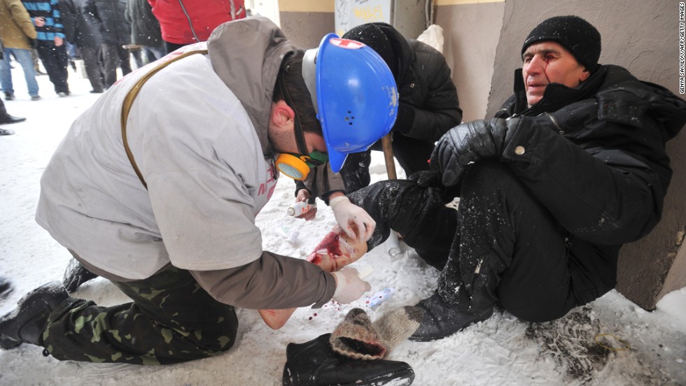 A medic treats an injured protester&#39;s leg during violent clashes between demonstrators and police.
