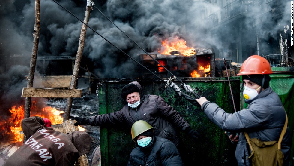 Ukrainian protesters use a huge catapult to throw stones at riot police as tires burn in Kiev on Thursday, January 23.