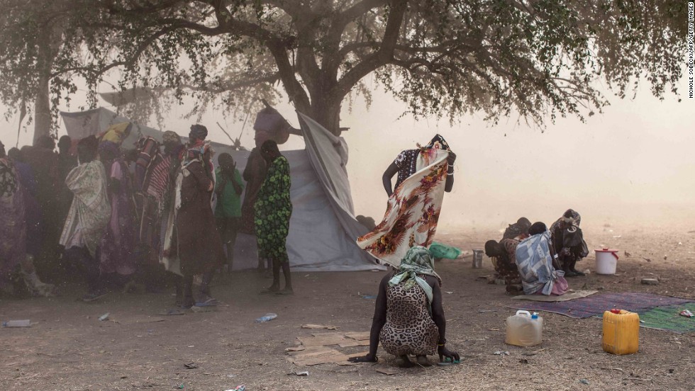 A woman covers her face as a U.N. helicopter takes off from Minkammen, where people receive food aid and other items from a recent International Committee of the Red Cross on Wednesday, January 8.