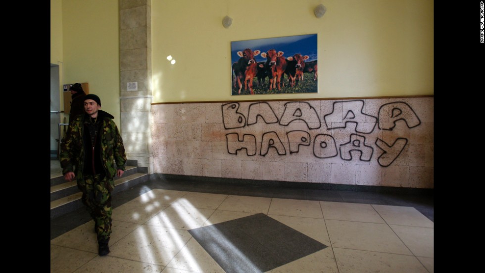 A protester passes past graffiti that reads &quot;Government for People&quot; in the Ministry of Agricultural Policy building in Kiev on January 24.