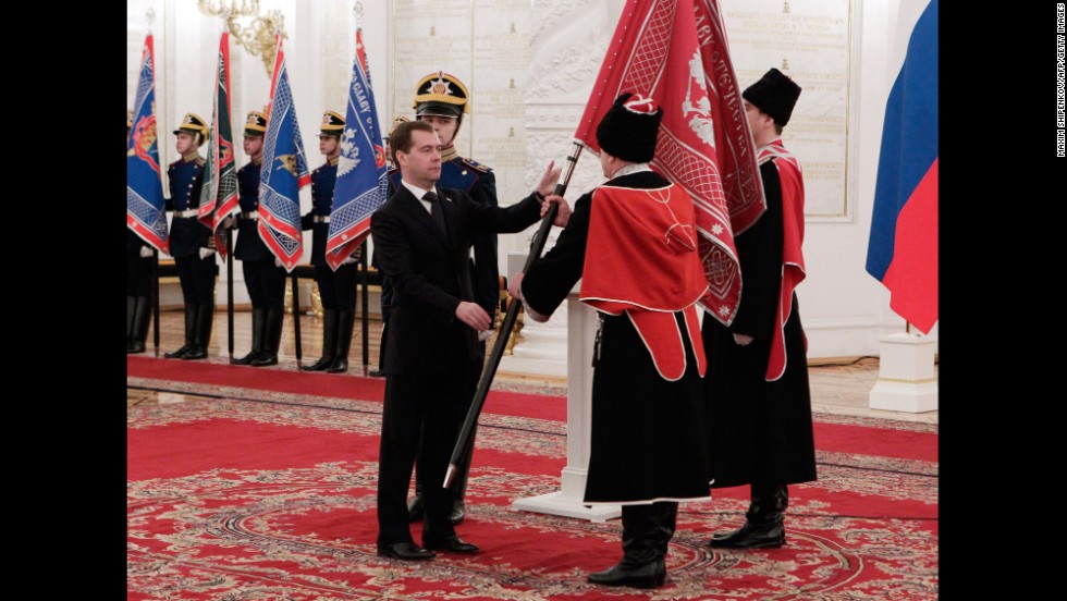 Then-Russian President Dmitry Medvedev hands over a flag  to one of the modern Cossacks organizations in Georgiyevsky (St. George) Hall of the Big Kremlin Palace in Moscow,in December 2011. 