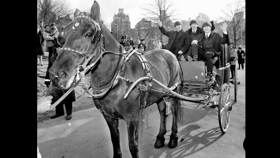 Three of The Beatles -- from left, Ringo Starr, Paul McCartney and John Lennon -- wave from a horse-drawn carriage in New York&#39;s Central Park on February 8, 1964. George Harrison was off resting a sore throat.