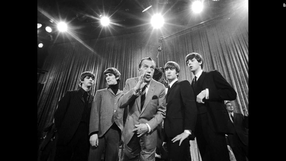 Television host Ed Sullivan, center, stands with The Beatles on February 9, 1964, during a rehearsal for the band&#39;s appearance on &quot;The Ed Sullivan Show.&quot; The iconic television appearance remains one of the highest-rated nonsports programs of all time. Nielsen estimated that 45% of the country watched the show -- more than 73 million people then.