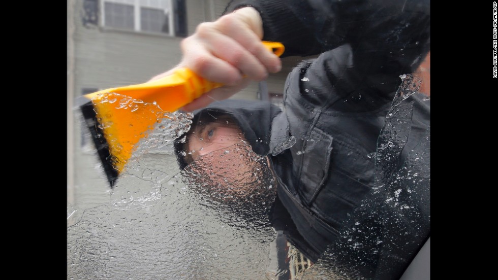 Kyle Malott scraps the ice off his girlfriend&#39;s car near Covington, Louisiana, on January 24. 