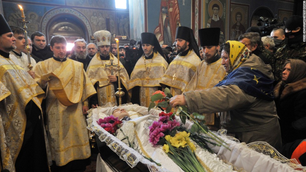 Orthodox priests lead the funeral service for slain protester Mikhail Zhiznevsky in Kiev on Sunday, January 26.