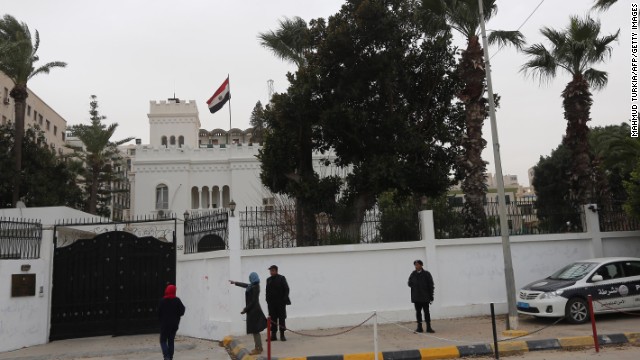 Women talk with policemen on January 25, 2014 in front of the Egyptian embassy, where Egyptian diplomats were seized earlier by kidnappers in Tripoli, Libya. At least 2 of the diplomats have been released.