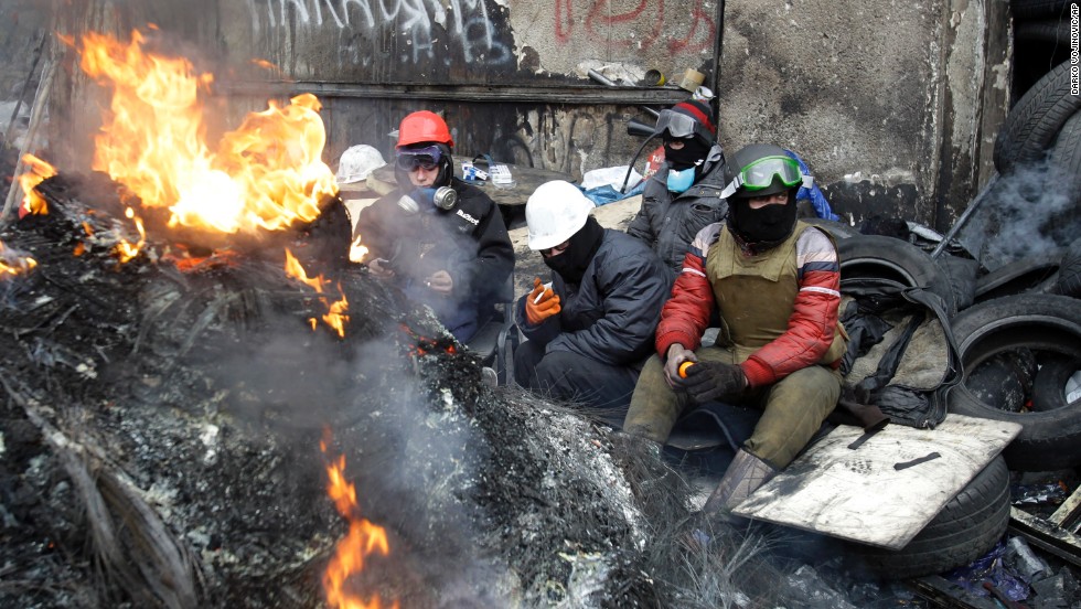 Protesters sit behind a barricade in Kiev on January 28.