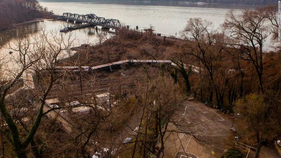 A Metro-North commuter train lies in the brush near the Hudson River after it derailed just north of the Spuyten Duyvil station December 1, 2013, in the Bronx borough of New York City. Four died and scores were injured after the seven-car train left the tracks as it was heading to Grand Central Terminal along the Hudson River line.