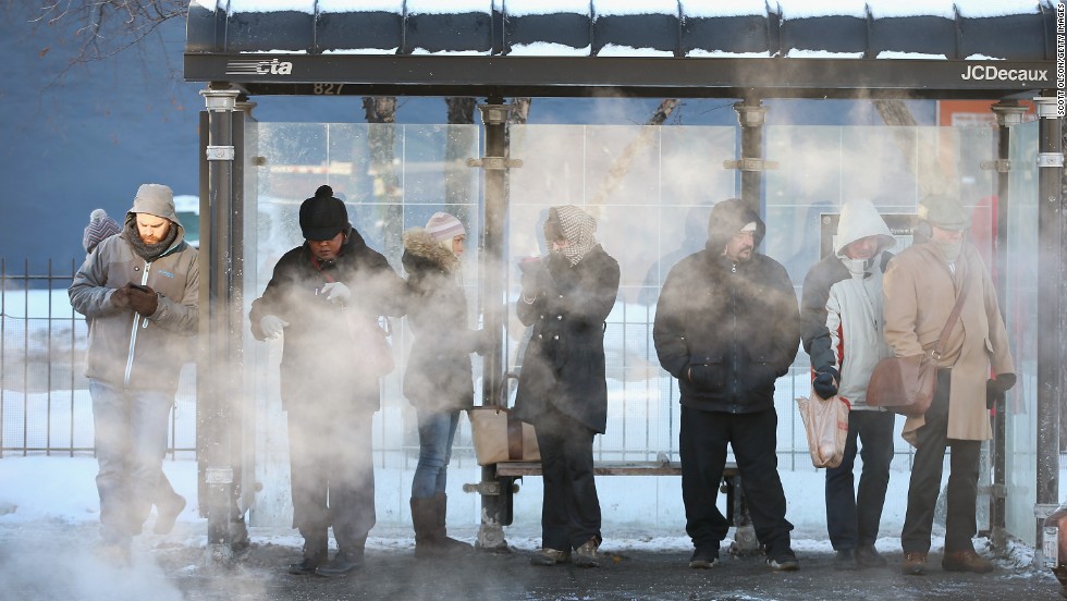 With temperatures around -10 degrees, commuters wait for a bus in Chicago on January 27.