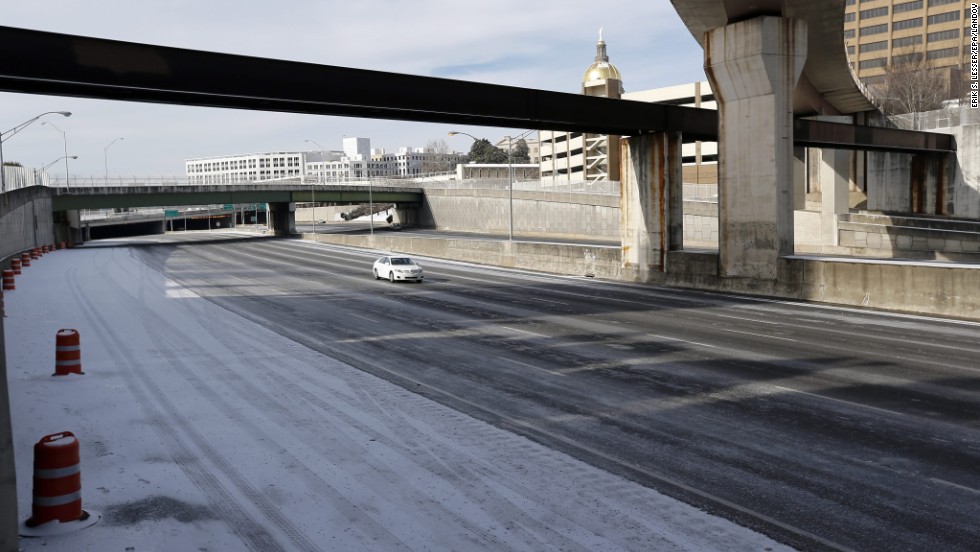 A lone car travels on Interstate 75/85 in downtown Atlanta on January 29, a day after the roadway was packed with vehicles.