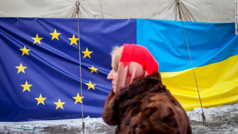 A woman walks past a tent displaying the European Union and Ukrainian flags in Independence Square on January 28, 2014 in Kiev, Ukraine. 