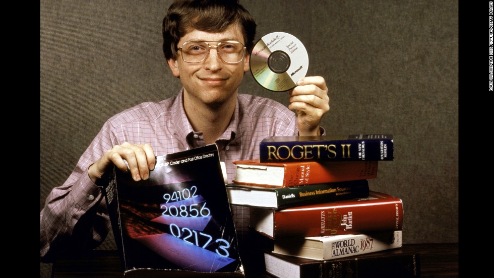 Gates holds up Bookshelf, a new compact disc for computers which holds all the information contained in the books pictured. 